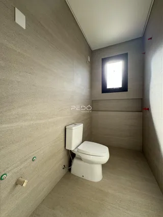 Banheiro com paredes e piso de cerâmica clara.