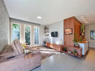 Sala de estar com grandes janelas e decoração moderna.