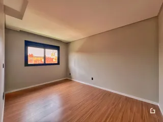 Ambiente interno de uma sala com piso de madeira clara.