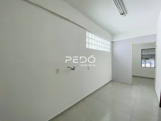 Interior de um ambiente com paredes brancas e piso claro.