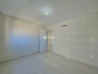 Ambiente interno de uma área com piso de cerâmica e paredes brancas.