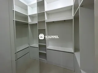 Foto de um interior com estantes e armários brancos em um ambiente residencial.