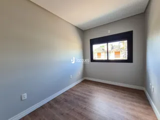Ambiente interno de uma sala com piso de madeira clara.
