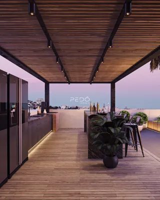 Vista de uma área gourmet externa com cozinha moderna e piso de madeira.