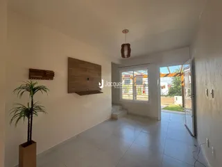A sala de estar apresenta paredes brancas e piso de cerâmica.
