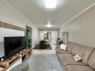 Sala de estar com sofá e televisão em um ambiente interno.