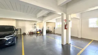 Imagem de um espaço interno amplo com piso de concreto e colunas brancas.