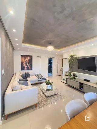 Sala de estar moderna com sofá branco e piso claro.