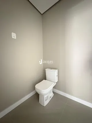 Foto de um corredor com um banheiro em uma residência.
