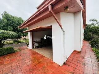 Vista da fachada de uma residência em Lajeado, Brasil, com área externa de piso de tijolos vermelhos.