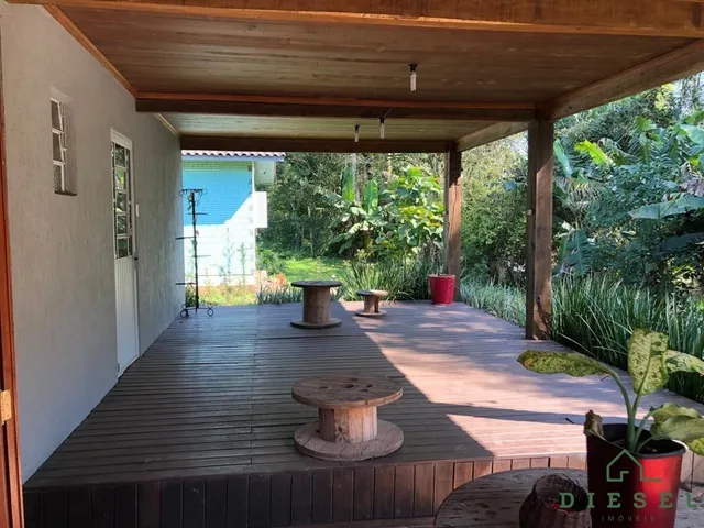 Deck de madeira ao ar livre com vista para a vegetação circundante.