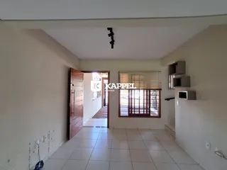 Hall de entrada com piso de cerâmica e paredes claras.