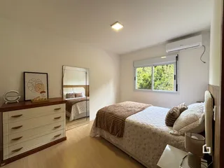 Quarto com cama e cômoda de madeira em um imóvel no Brasil.