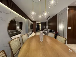 Uma sala de jantar com mesa de madeira e decoração moderna.