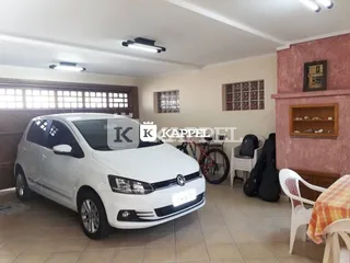 Sala de estar com piso de cerâmica e janelas de madeira.
