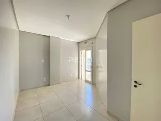 Corredor com paredes claras e piso de cerâmica.