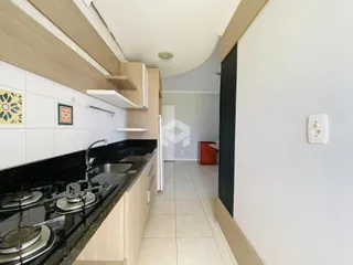 Cozinha moderna com bancada escura e armários claros.