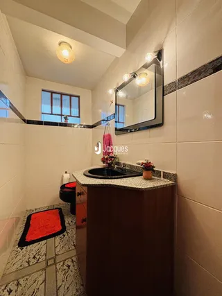Foto de um banheiro com revestimento de cerâmica e bancada de madeira.