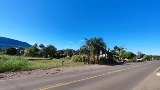 Vista externa da propriedade ao longo de uma estrada rural sob um céu azul.