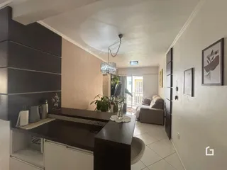 Interior de uma sala de estar com cozinha em um apartamento.