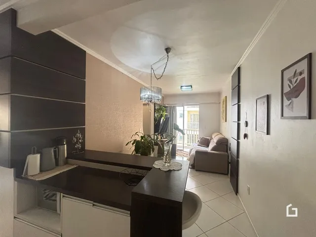 Interior de uma sala de estar com cozinha em um apartamento.