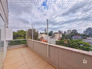 Vista de uma varanda com piso de cerâmica e cerca de arame.