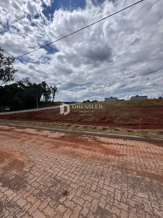 Vista externa da propriedade com estrada de terra no primeiro plano.