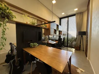 Ambiente interno com mesa de madeira e painel decorativo.