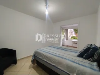 Quarto com cama de casal em ambiente claro.