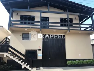 Fachada de uma residência com escadaria externa e portão de garagem em Lajeado, Brasil.