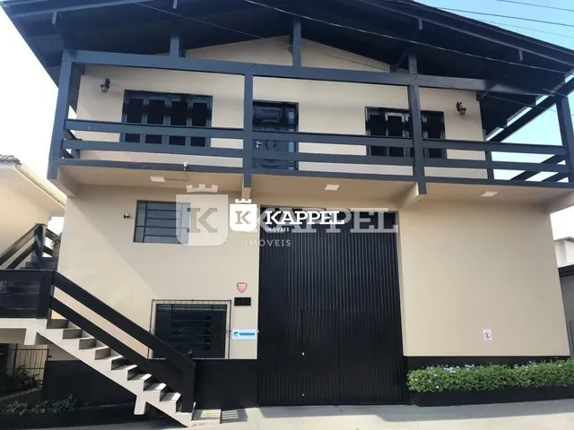 Fachada de uma residência com escadaria externa e portão de garagem em Lajeado, Brasil.