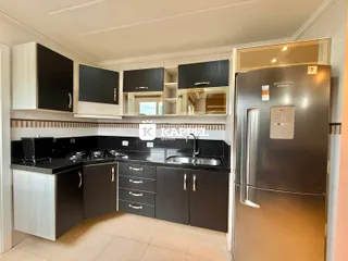 Foto de uma cozinha moderna com armários pretos e bancadas escuras.