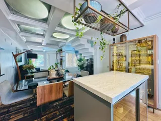 Imagem de um ambiente interno de sala de estar e jantar com teto abobadado.