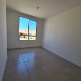 Uma sala ampla com piso de cerâmica e grande janela.