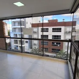 Vista externa de um apartamento com grandes janelas de vidro.
