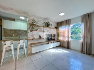 Sala de estar moderna com piso de cerâmica clara e grandes janelas.