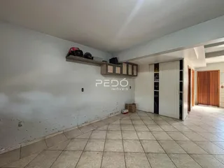 Interior de uma sala com piso de cerâmica e armários brancos.