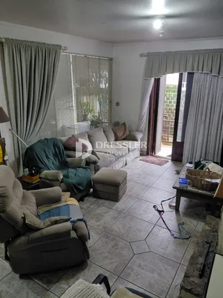 Sala de estar com sofá e piso de cerâmica em imóvel no Brasil.