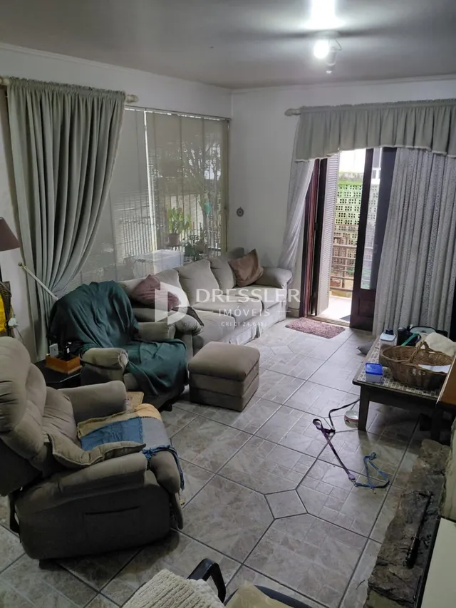 Sala de estar com sofá e piso de cerâmica em imóvel no Brasil.