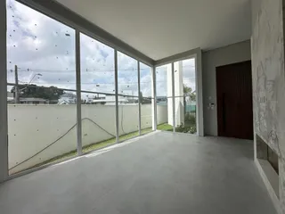 Ambiente interno com grandes janelas que oferecem vista para o exterior.