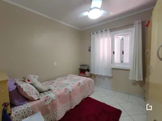 Quarto interno com cama de casal e teto com ventilador.