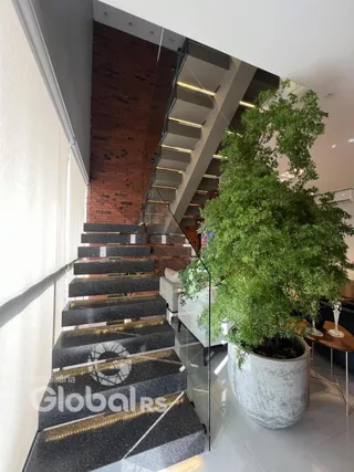 Foto da escadaria e parede de tijolos de uma residência.