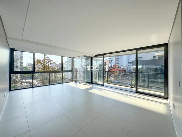 Sala de estar com grandes janelas que oferecem vista para o exterior.