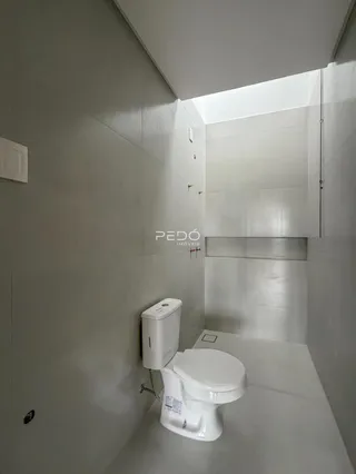 Foto de um banheiro moderno com azulejos brancos e vaso sanitário.