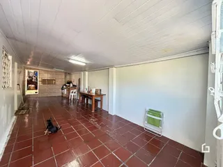 Interior de uma área com piso de cerâmica vermelha no imóvel.