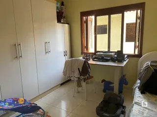 Quarto com armários brancos e cama visível.