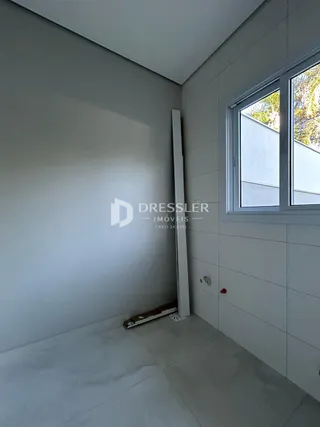 Interior de um ambiente com paredes brancas e piso claro.