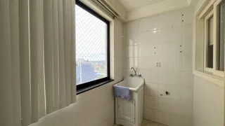 Banheiro com paredes brancas e janela.