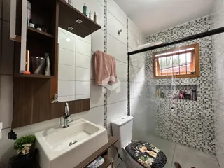 Foto de um banheiro com revestimento de azulejos brancos e cinzas.