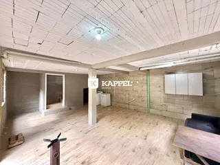 Vista interna de um ambiente com teto exposto e piso de cerâmica.